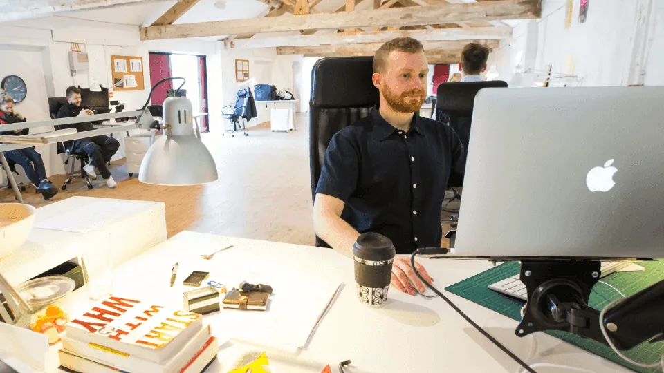 People working at desks in an open-plan office.