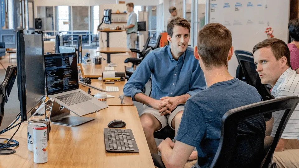 Technology consultants discussing code in an office