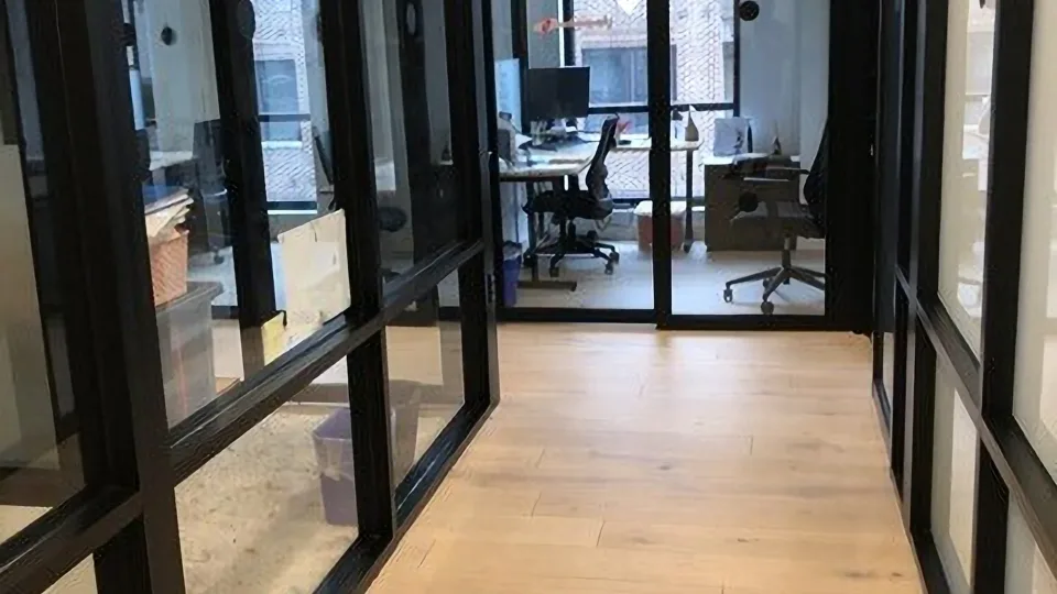 Office corridor with glass-walled meeting rooms.